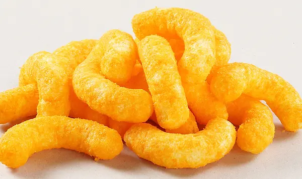 orange cheese puff snacks laying in a pile together